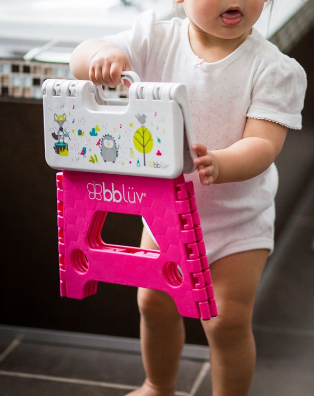 Child with a portable step stool in the hands