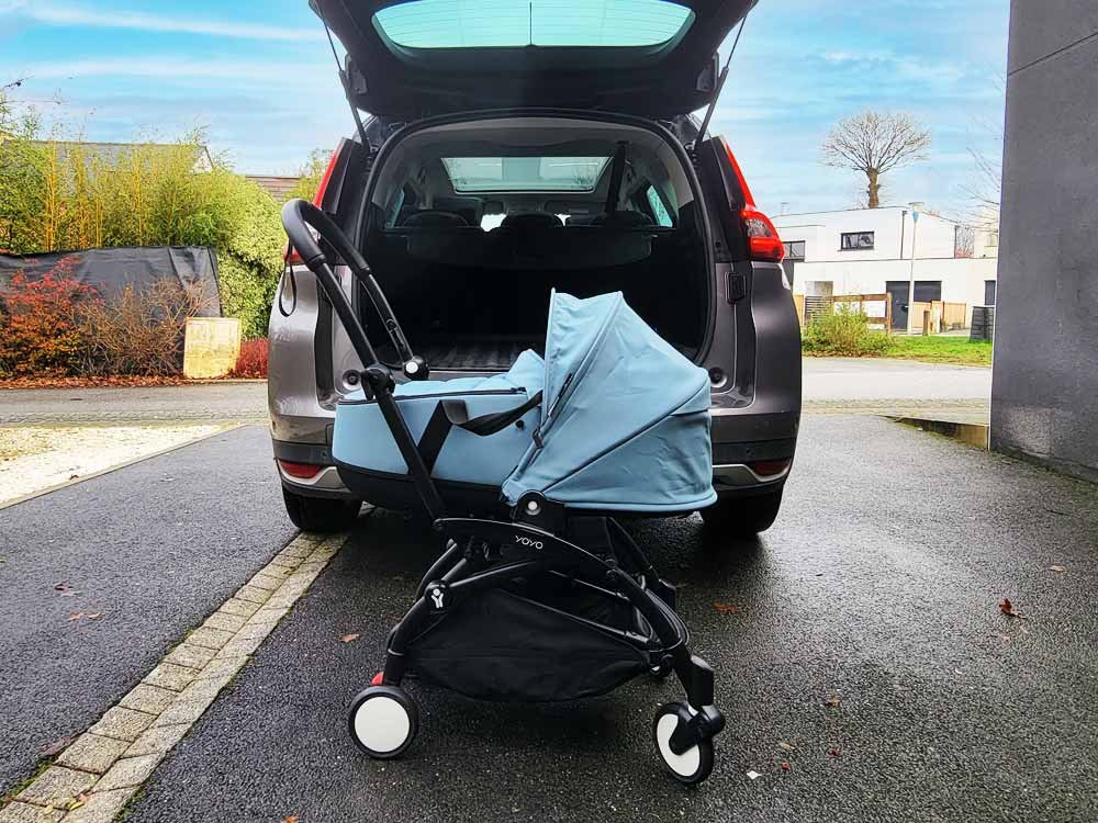 YOYO Babyzen Aqua stroller basket in front of the trunk of a car