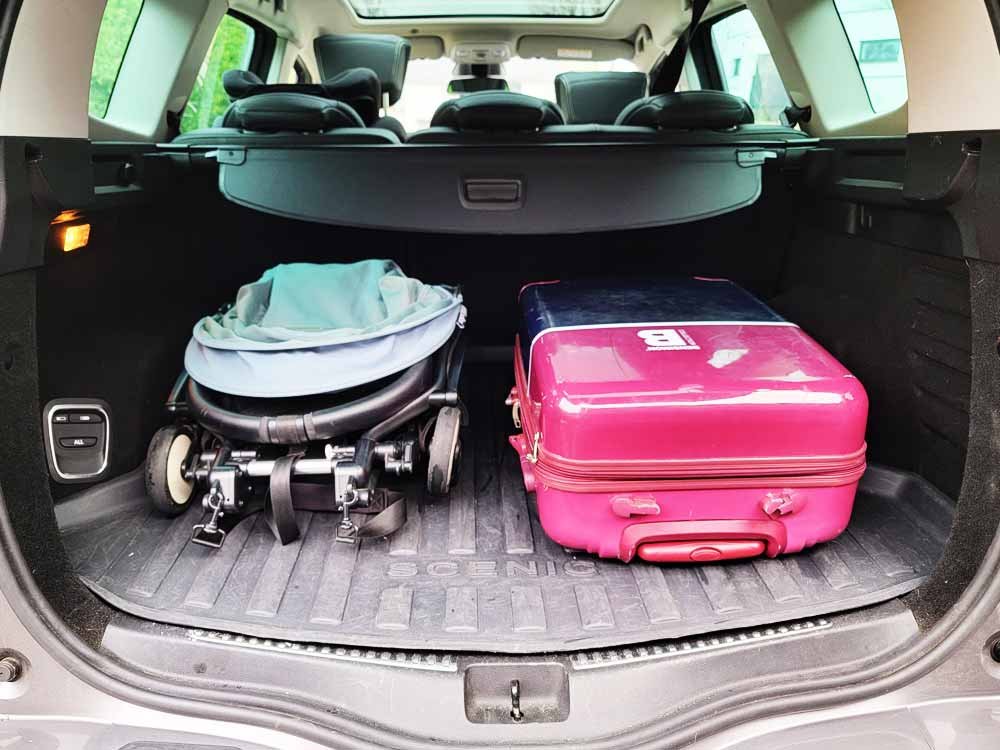 YOYO Babyzen 6+ stroller folded in the trunk of a car with a cabin suitcase